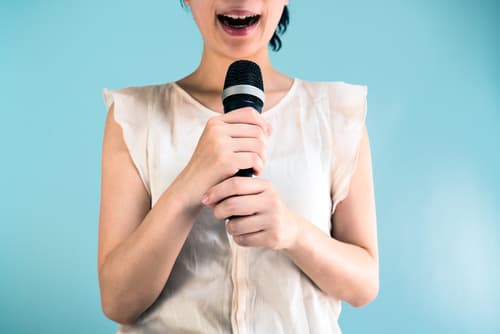 Femme tenant un micro, bouche ouverte